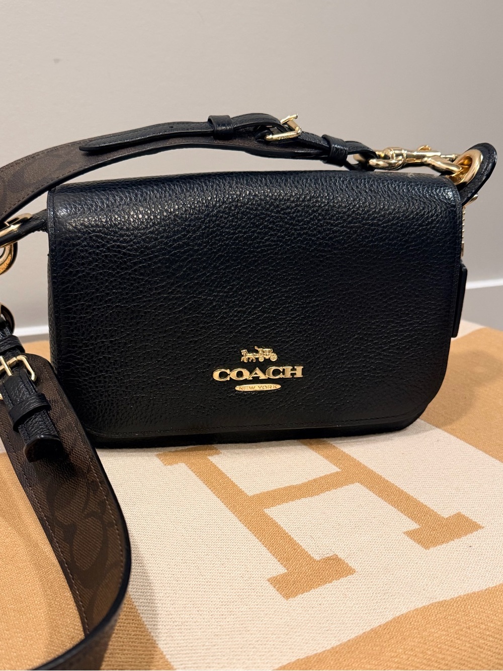 COACH Black Pebbled Leather Crossbody Bag strap is Coach Monogram Print.